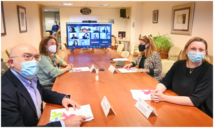reunion Varias personas reunidas en torno a una mesa con un sistema de videoconferencia