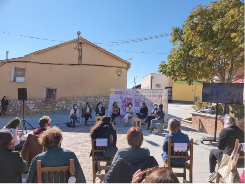 imagen_encuentro1 Foto de una charla de varias mujeres, con público, situada en la plaza de un pueblo