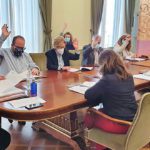 Foto de varias personas votando a mano alzada en una sala de juntas