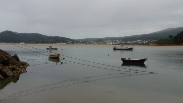 Foto de unas barcas fondeadas en una playa