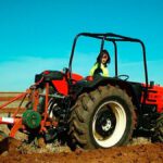 agricultora trabajando el campo en un tractor